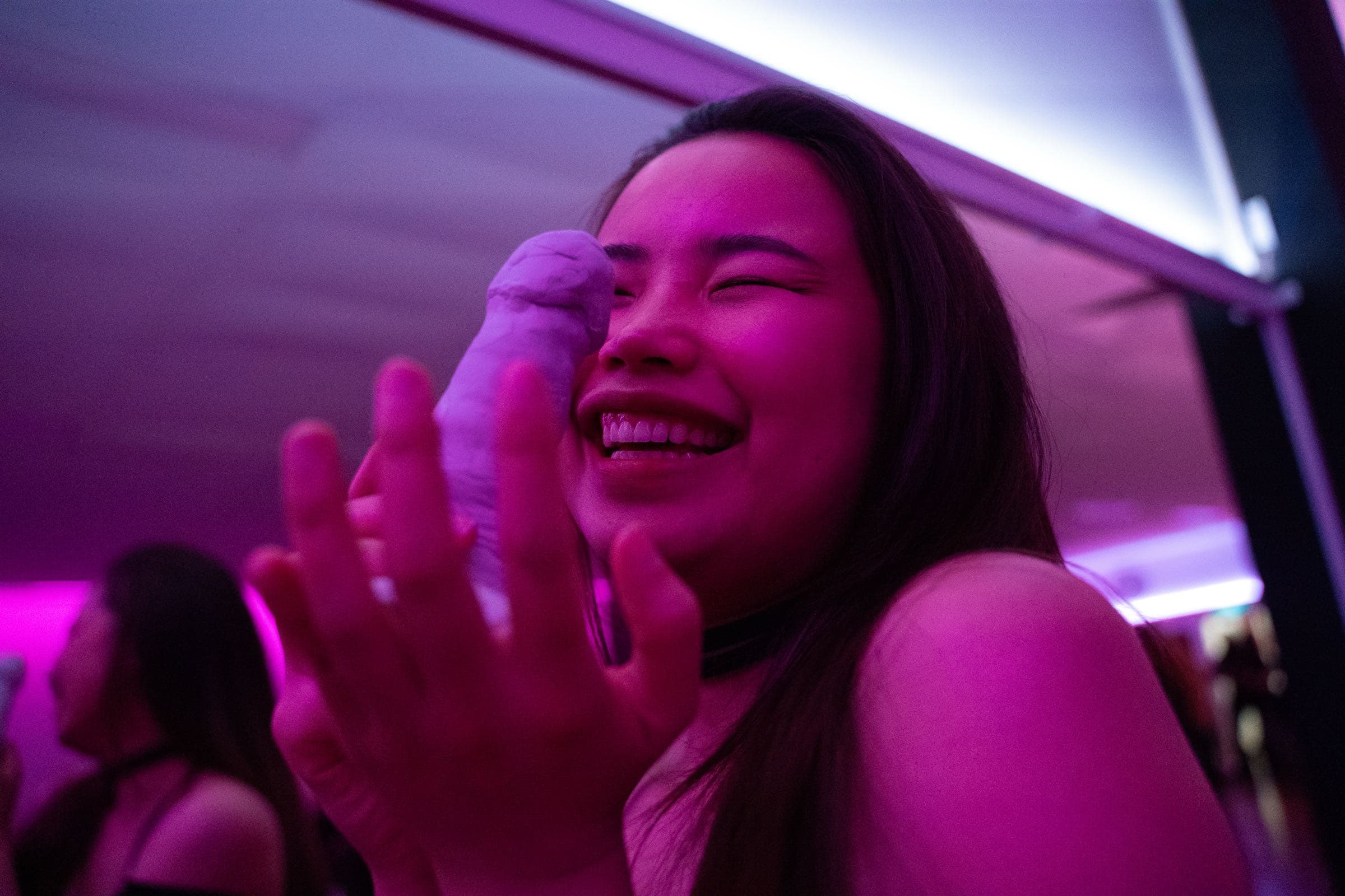 A guest laughing with a clay sculpture at a hens party.