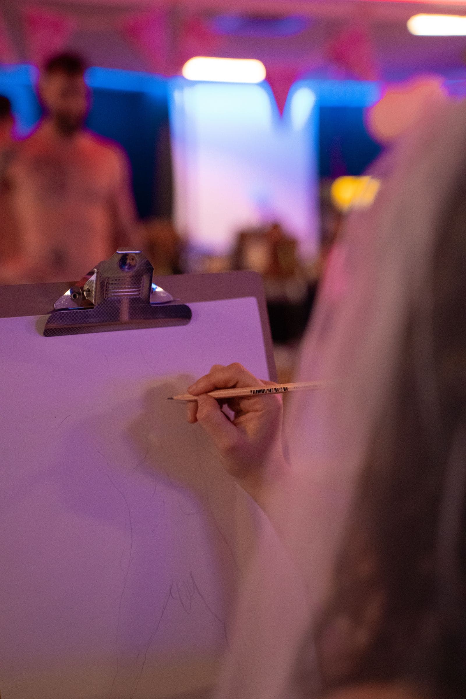 A guest drawing the model at a life drawing hens party.