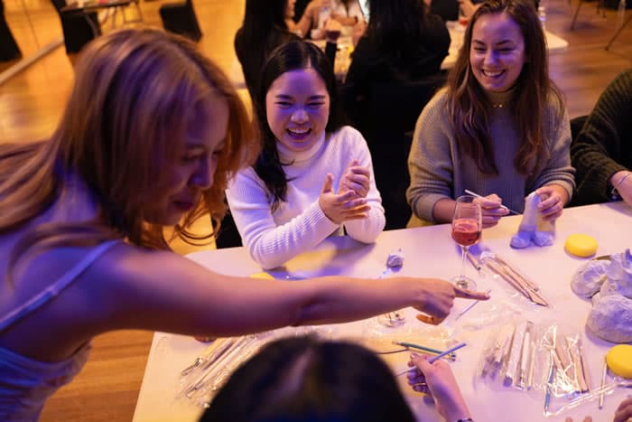 Guests laughing around a table at a hens party.